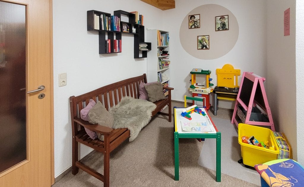 Gemütliche Kinderecke mit Spielzeug und Bücherregalen.