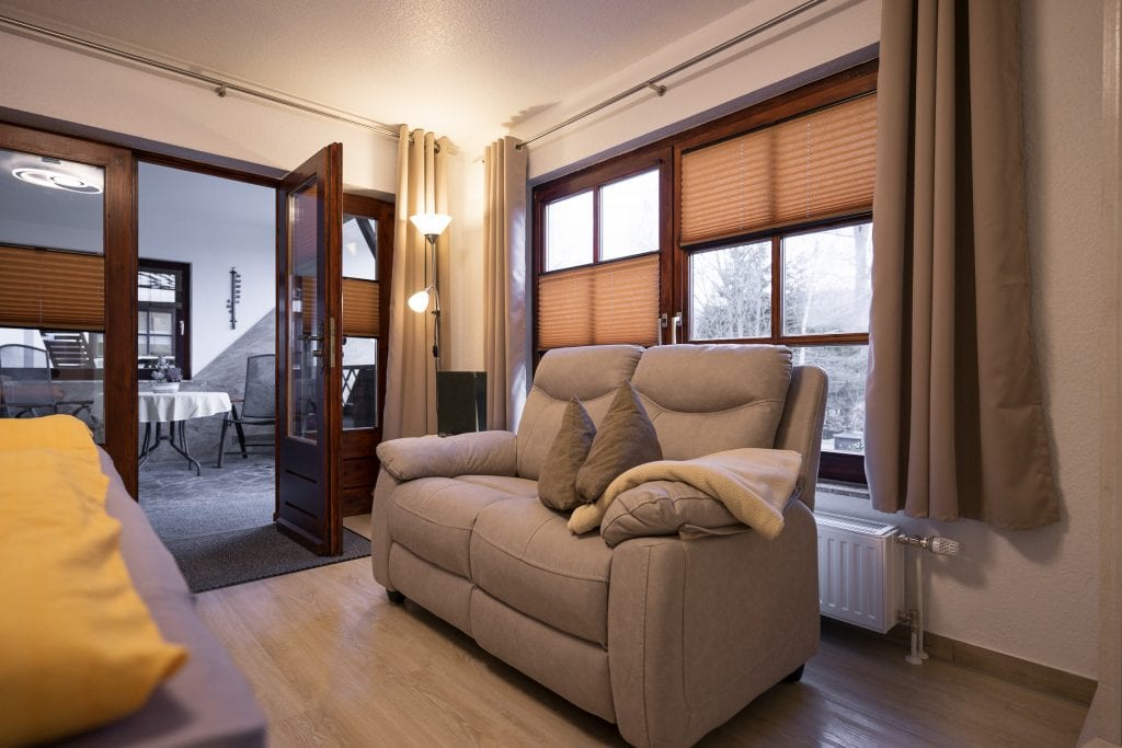 En hyggelig stue med sofa og tilstødende terrasse.