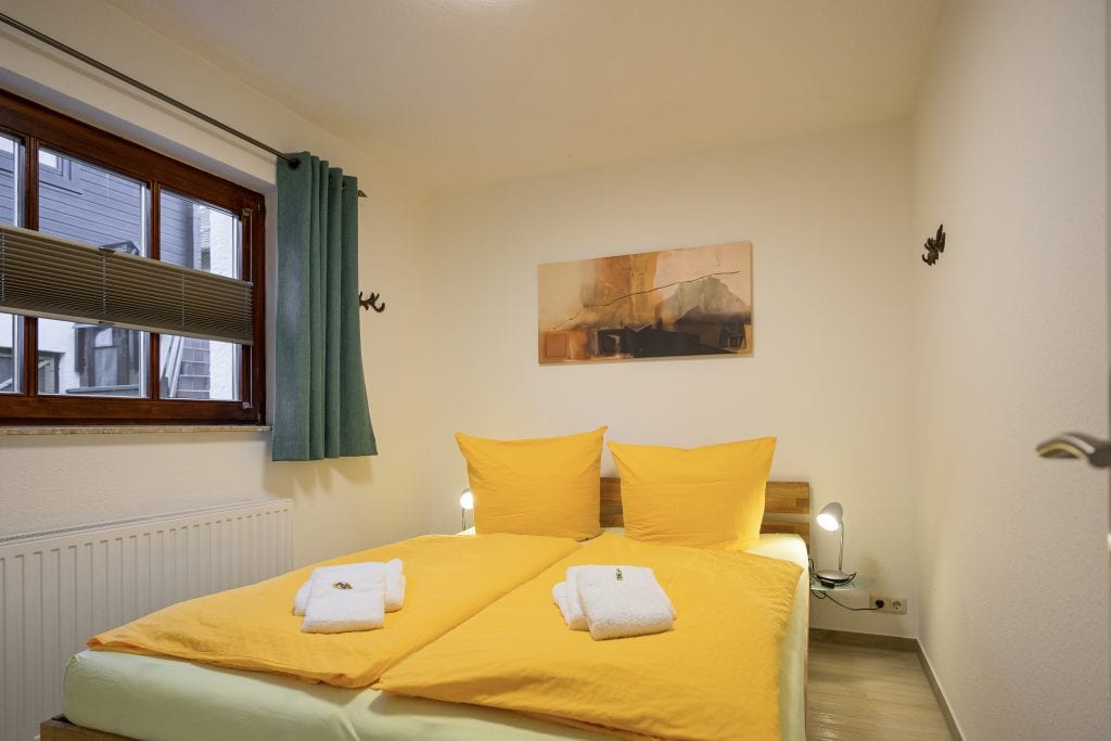 Helles Schlafzimmer mit Doppelbett.