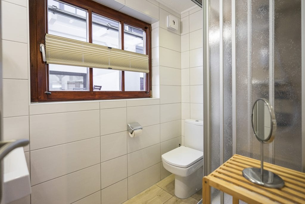 Modernes helles Badezimmer mit Dusche und Fenster.