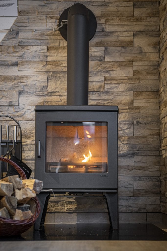 Moderner Kaminofen mit brennendem Feuer.