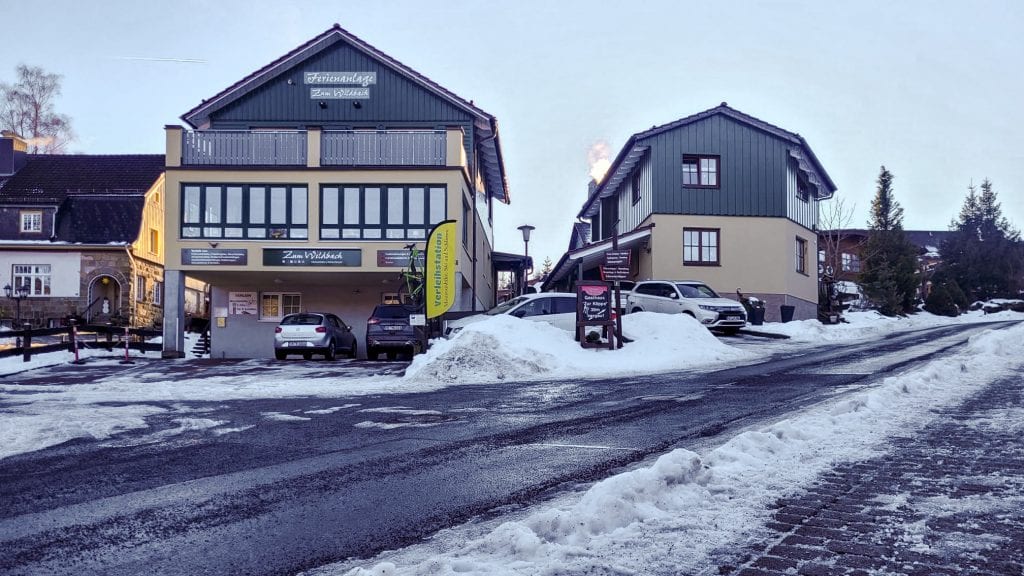 Winterliche Ferienanlage in Schierke am Brocken und Straße mit Schnee.