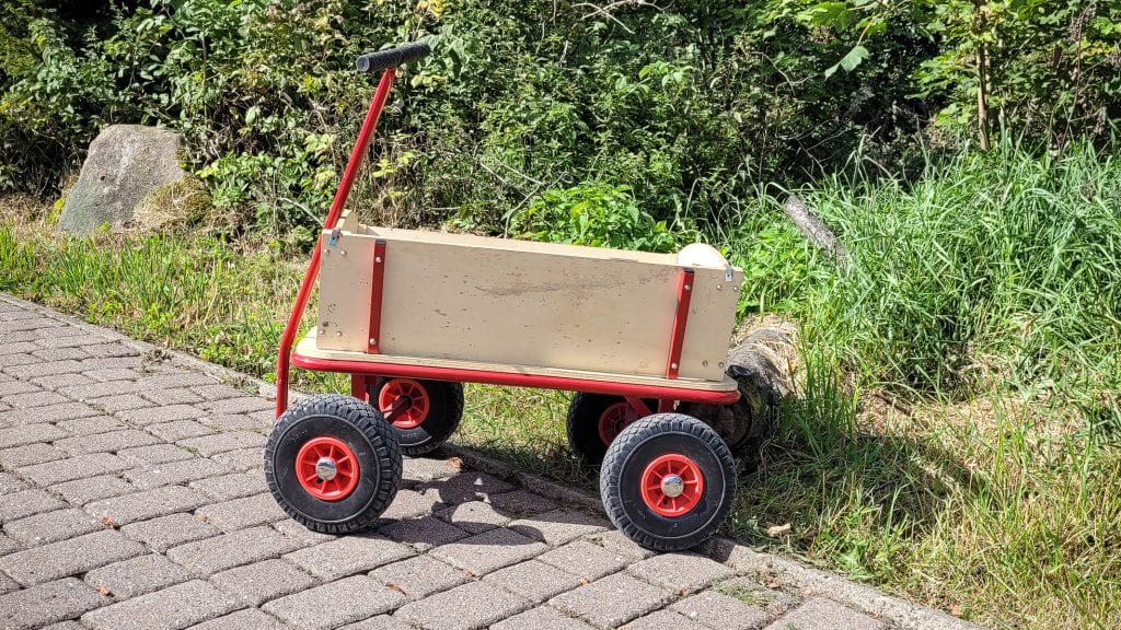 Holzkarren am Wegrand auf Pflastersteinen