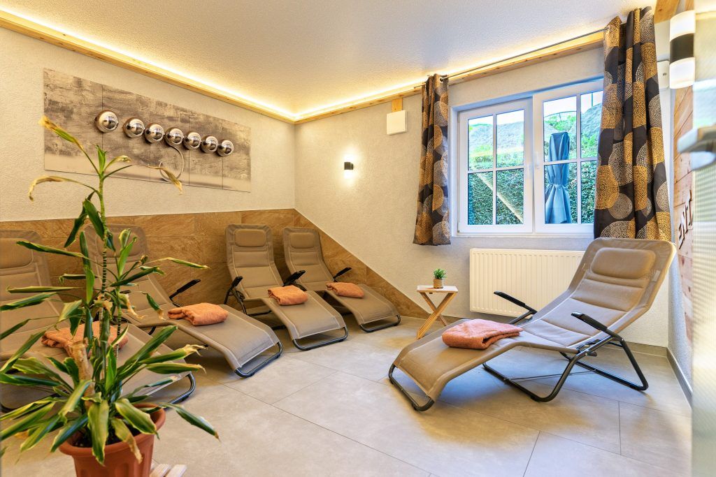 Cozy relaxation room with loungers and plants.