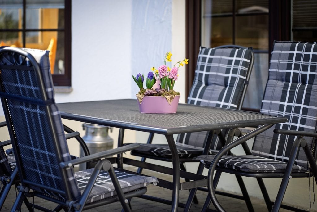 Gartentisch mit Blumenarrangement auf Terrasse