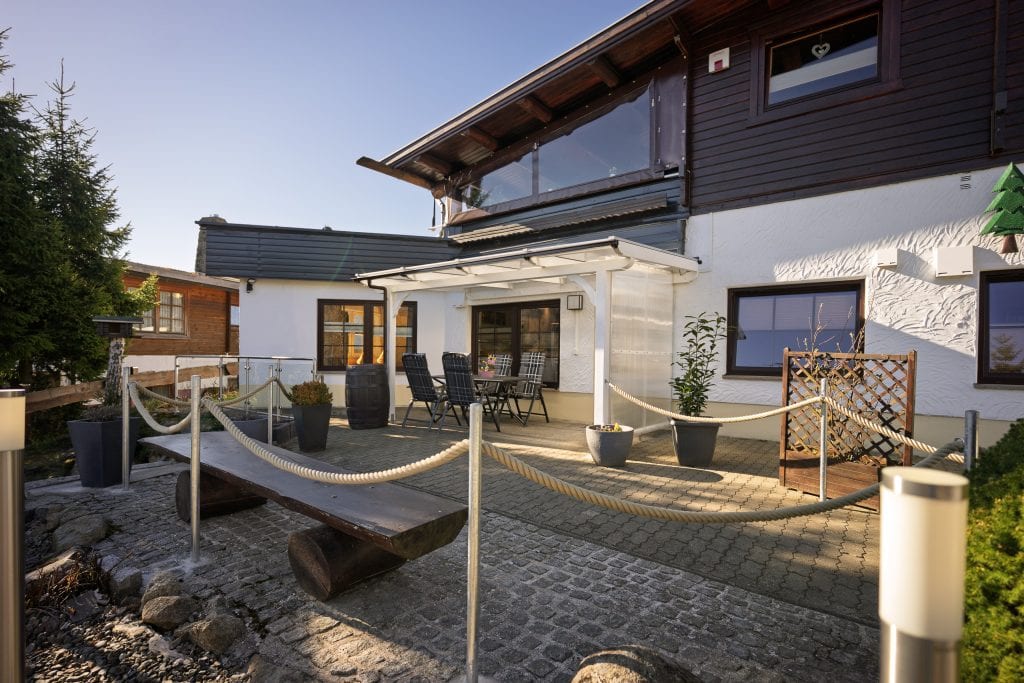 Sonnige Terrasse mit Sitzgruppe am modernen Haus