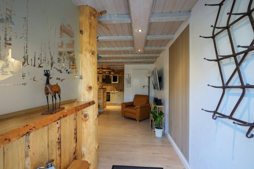 Rustikaler Holzflur mit Sessel und Küchenzeile