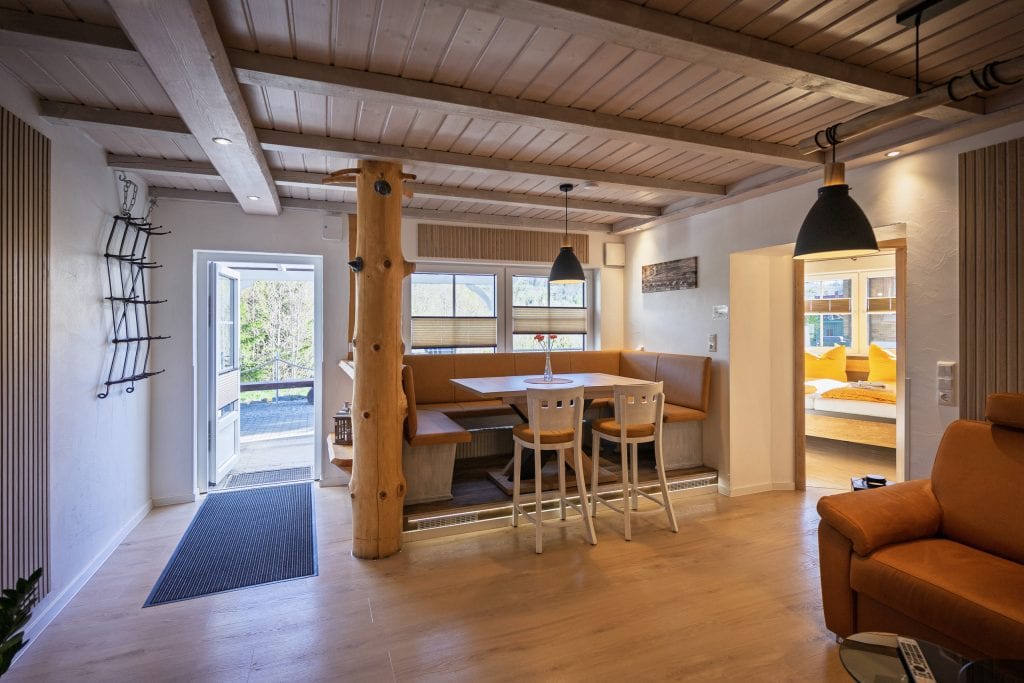 Gemütlicher Wohnraum mit Holzbalken und Essecke