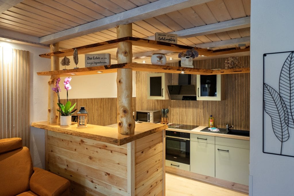 Rustikale Holzküche mit Bartheke und offenen Regalen