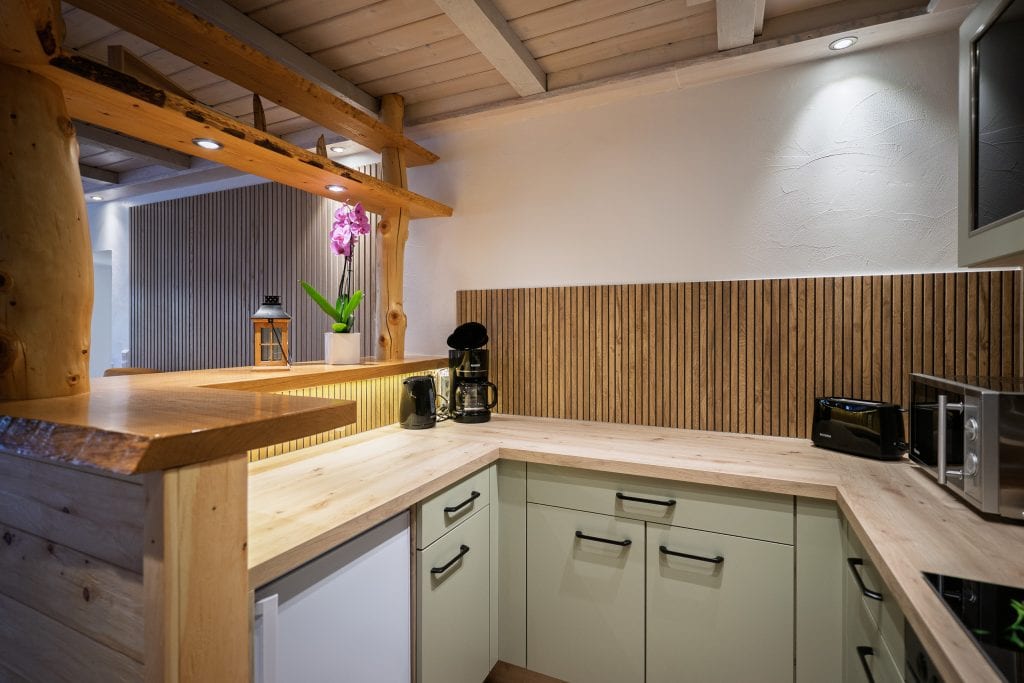 Moderne Küche mit Holzbalken und heller Arbeitsplatte