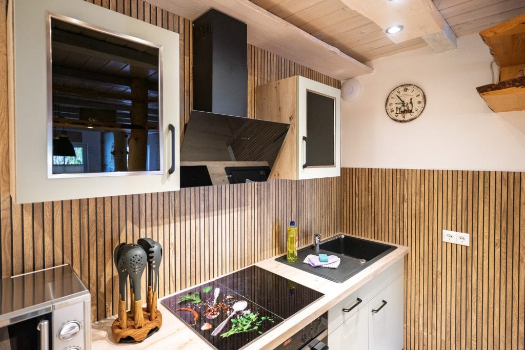Moderne Küche mit Holzverkleidung und schwarzen Akzenten