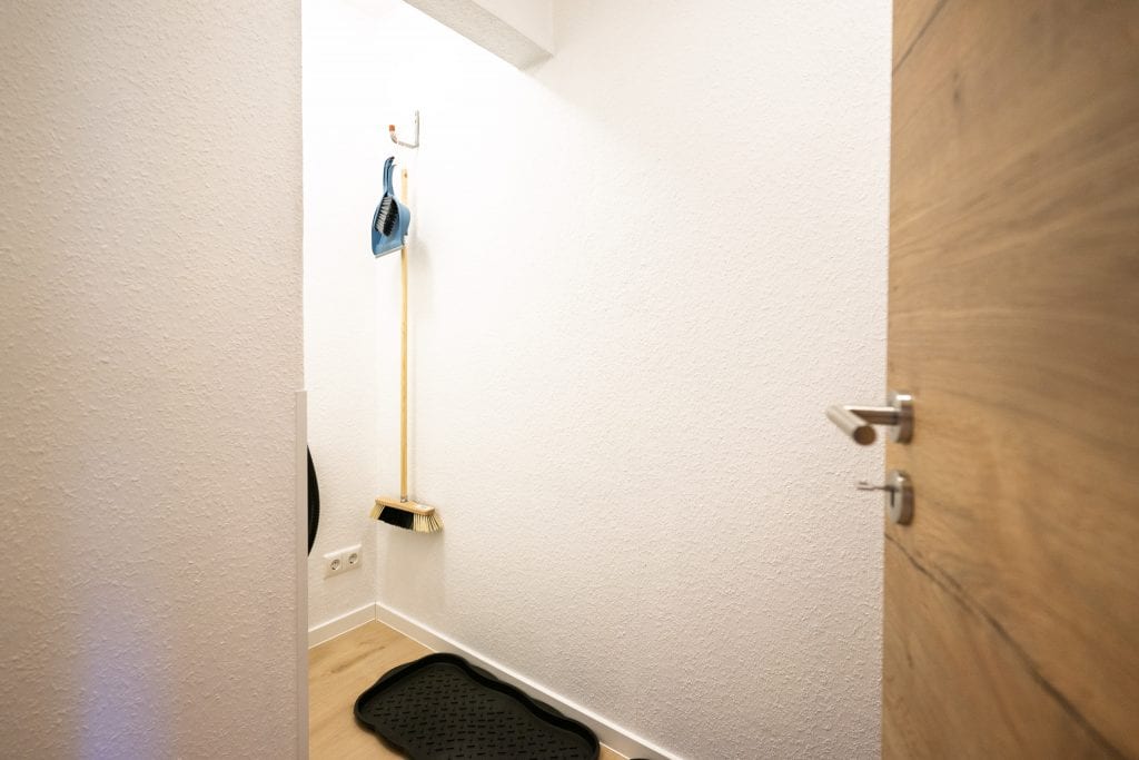 Besen und Kehrschaufel in kleiner Abstellecke