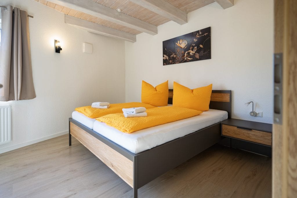 Modernes Schlafzimmer mit gelber Bettwäsche und Holzbett