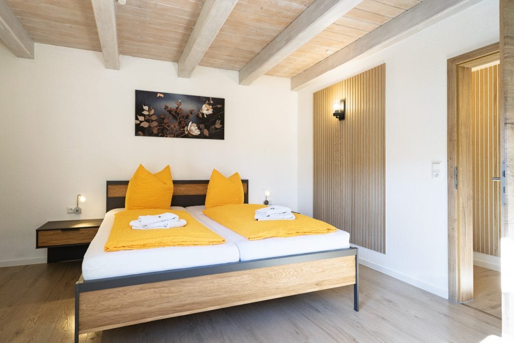 Modernes Schlafzimmer mit Doppelbett und gelber Bettwäsche