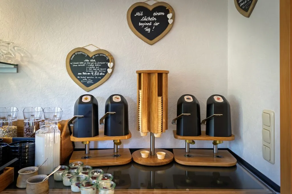 Frühstücksbuffet mit Frühstückszutaten und Automaten.