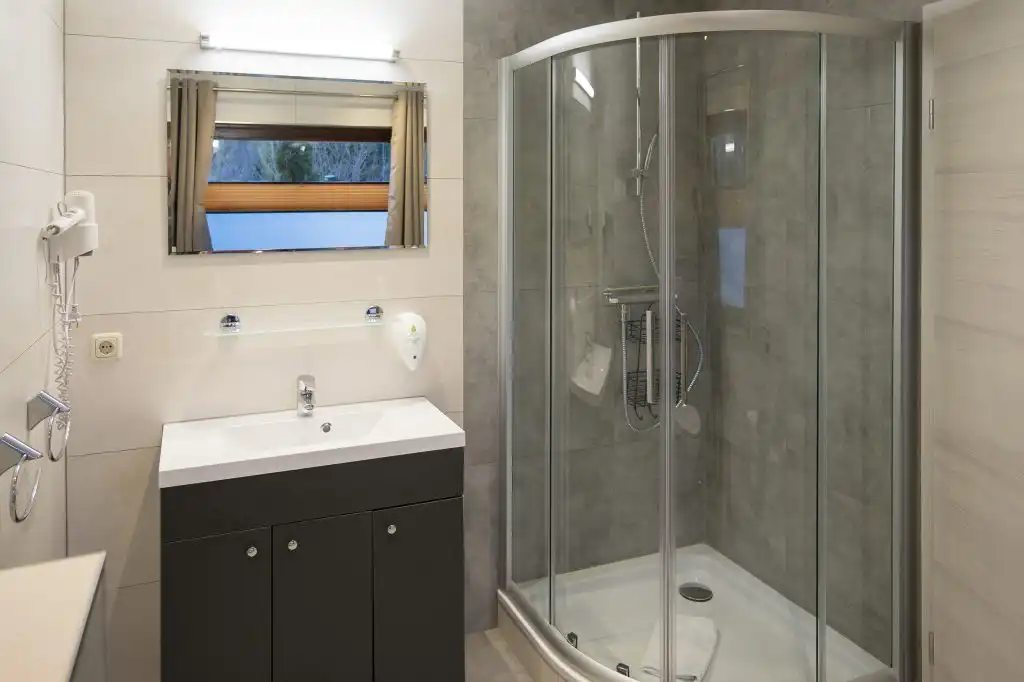 Moderne badeværelse med bruser og håndvask.