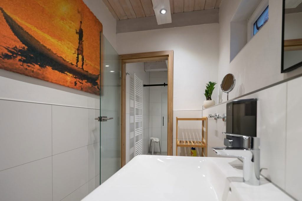 Moderne badeværelse med glasbruser og orange vægbillede