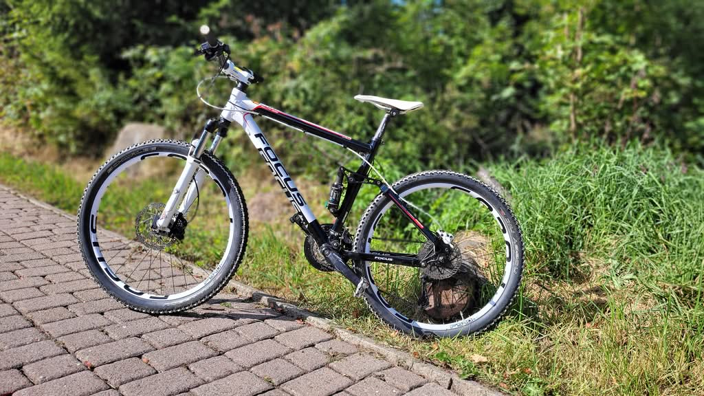 Mountainbike auf gepflastertem Weg im Grünen
