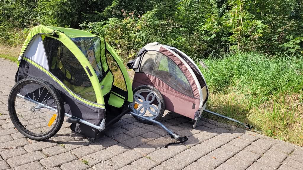 Zwei Fahrradanhänger für Kinder am Wegesrand