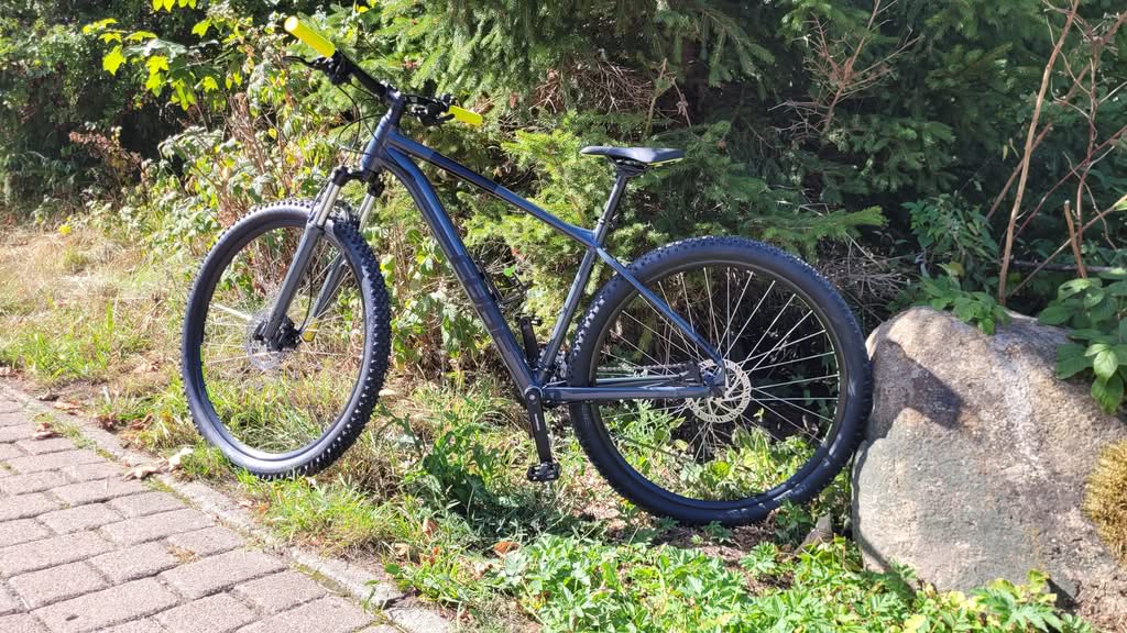 Mountainbike am Wegesrand neben Felsen im Grünen