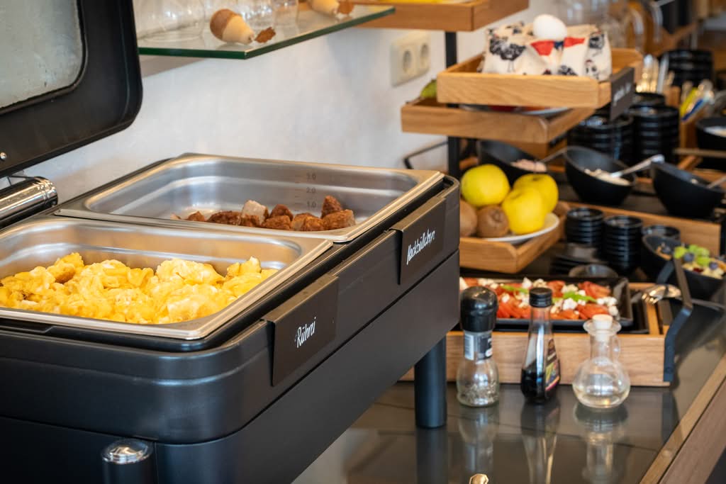 Frühstücksbuffet mit Rührei, Bratkartoffeln und Obst