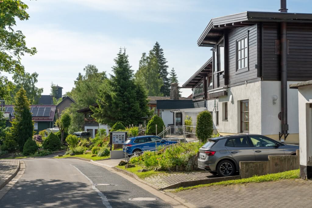 Ruhige Wohnstraße mit Einfamilienhäusern und parkenden Autos