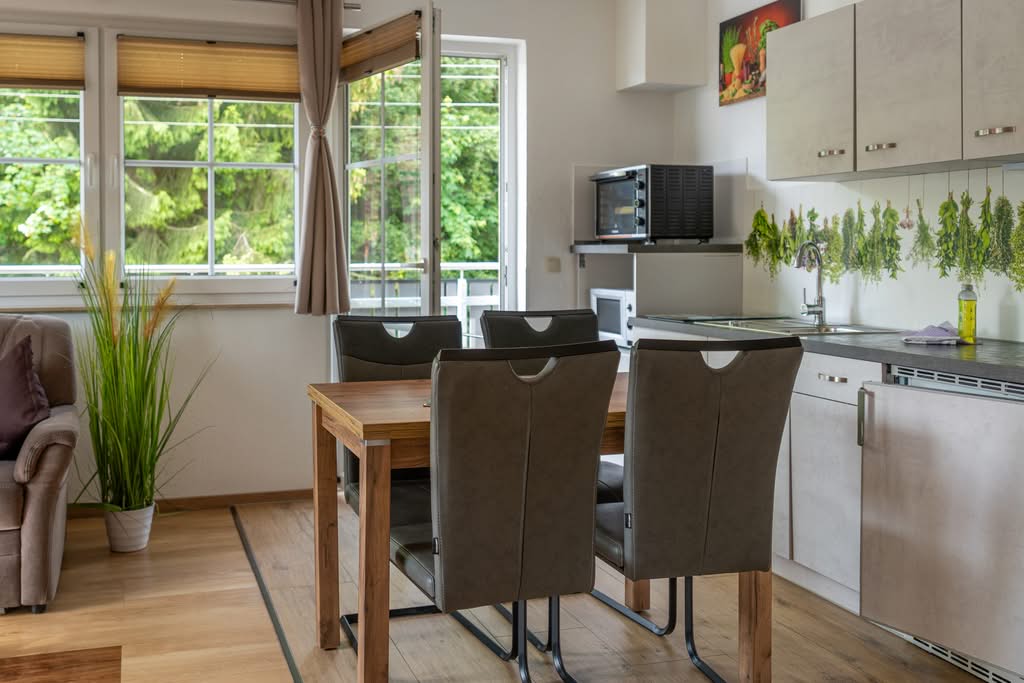 Helle moderne Küche mit Esstisch und großen Fenstern