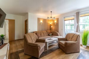 Gemütliches Wohnzimmer mit braunem Sofa und Sesseln
