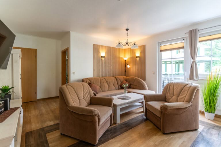 Gemütliches Wohnzimmer mit braunem Sofa und Sesseln
