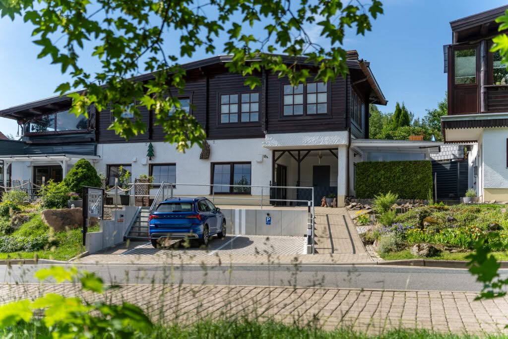 Modernes Wohnhaus mit Holzfassade und blauem Auto