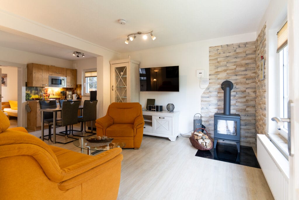 Modernes Wohnzimmer mit Kaminofen und offener Küche