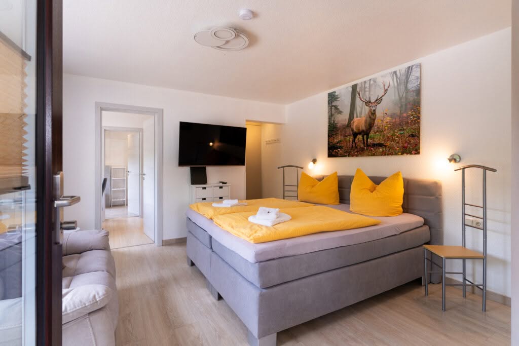 Modernes Schlafzimmer mit Doppelbett und gelber Bettwäsche