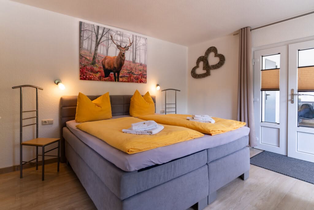 Gemütliches Schlafzimmer mit Doppelbett und Hirschbild