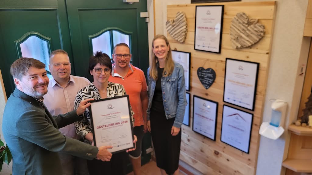 Oorkonde publiekslieveling 2026 voor Ferienanlage Zum Wildbach, op de achtergrond andere onderscheidingen